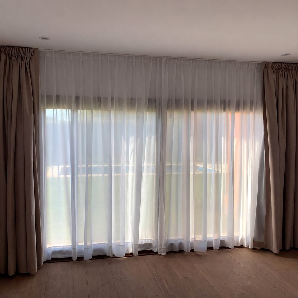 Cortinas de gasa y blackout instaladas en un ambiente